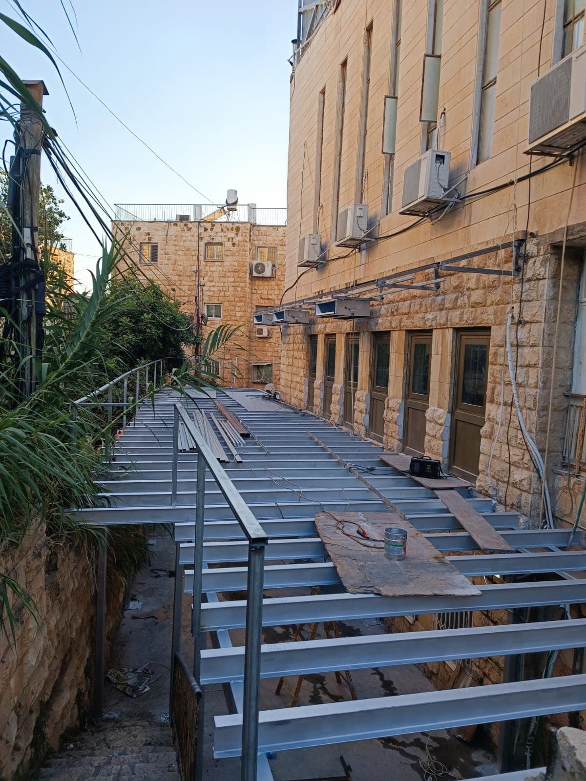 פרופילי פלדה מגולוונים מותקנים מעל קונסטרוקציית הפלדה הראשית, בשעת בין־ערביים